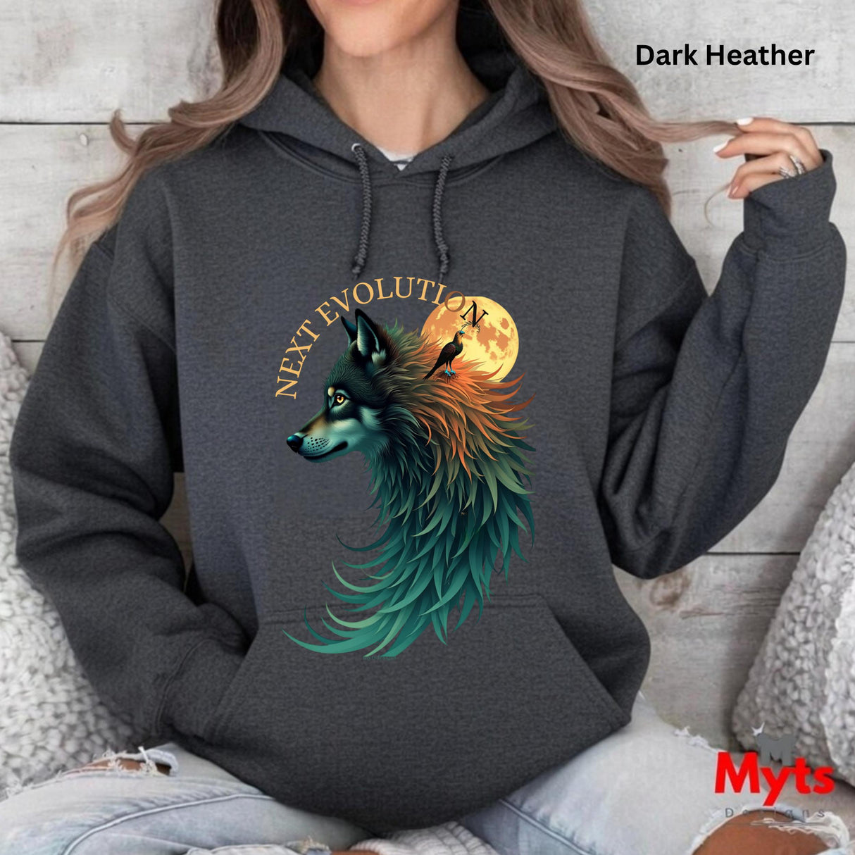 A woman wearing a dark heather hoodie with a colorful graphic of a wolf in front of a full moon and the text 'NEXT EVOLUTION'.
