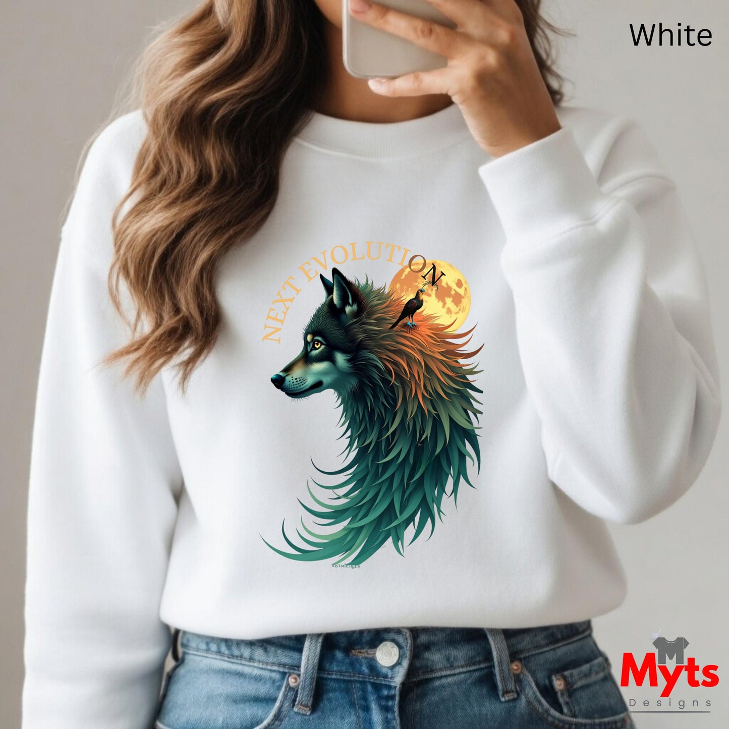 A person wearing a white crewneck sweatshirt with a colorful graphic of a wolf's head in profile, blending teal, green, orange, and yellow tones, with the text 'NEXT EVOLUTION' above it. The person is holding a phone to take a mirror selfie, with blue jeans visible at the bottom.