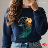 A person wearing a navy crewneck sweatshirt with a graphic of a wolf in front of a full moon and the text 'NEXT EVOLUTION'. The person is taking a mirror selfie, and the background is a plain light gray wall.