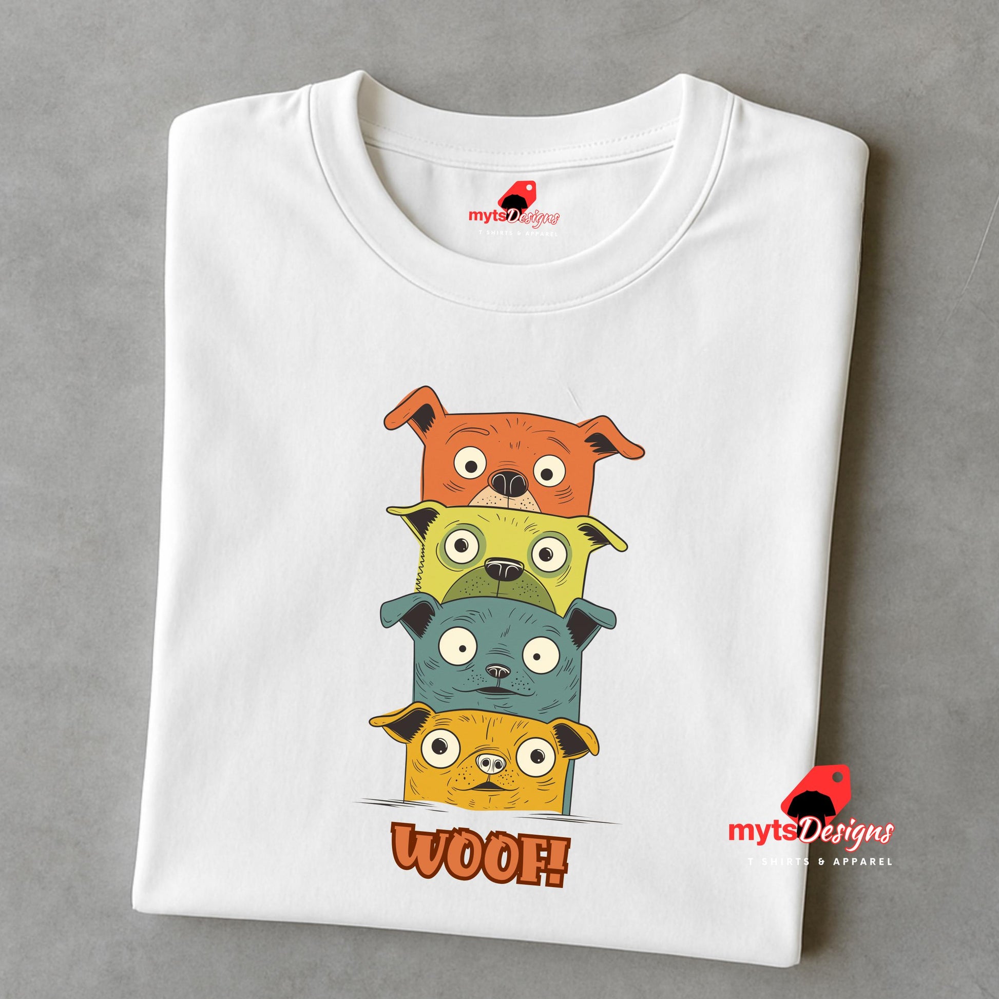 A folded white T-shirt featuring a quirky graphic of four stacked cartoon dogs in orange, yellow, teal, and golden tones with playful “WOOF!” text below the design.