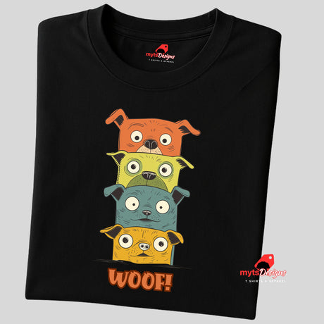 A folded black T-shirt featuring a quirky graphic of four stacked cartoon dogs in orange, yellow, teal, and golden tones with playful “WOOF!” text below the design.