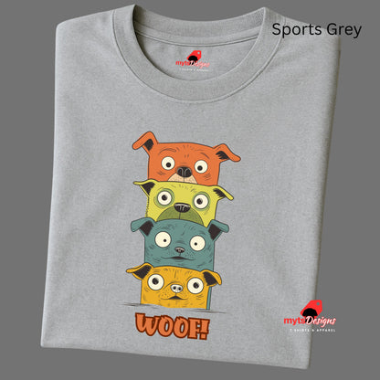 A folded sports grey T-shirt featuring a quirky graphic of four stacked cartoon dogs in orange, yellow, teal, and golden tones with playful “WOOF!” text below the design.