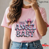 Person wearing a pink t-shirt with 'Y2K ANGEL BABY' design, holding a phone.