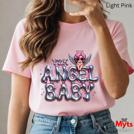 Person wearing a pink t-shirt with 'Y2K ANGEL BABY' design, holding a phone.