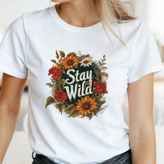 Woman wearing a soft white t-shirt with a stylish boho "Stay Wild" graphic design, perfect for nature lovers.