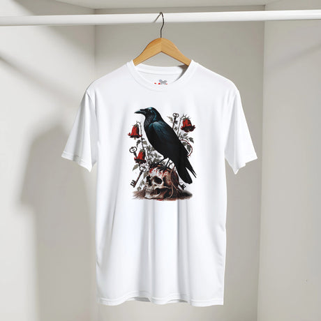 A white short-sleeve crewneck t-shirt hanging on a wooden hanger against a light gray wall. The shirt features a detailed graphic print on the front showing a black raven perched on a skull, surrounded by red roses and silver keys.