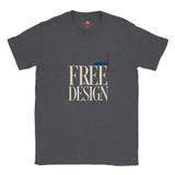 A dark heather gray t-shirt with a graphic print on the front reading 'FREE BY DESIGN' in beige serif letters, featuring a geometric flag design in red, white, and blue.