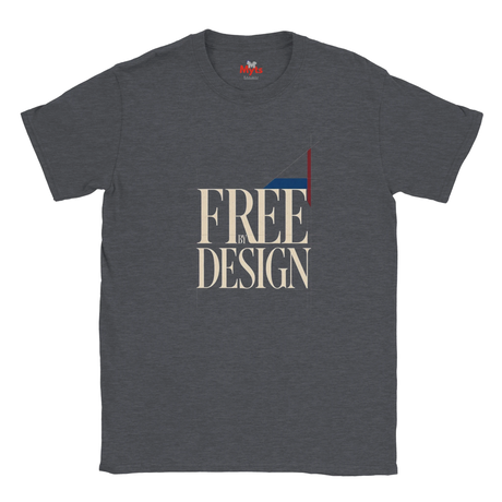 A dark heather gray t-shirt with a graphic print on the front reading 'FREE BY DESIGN' in beige serif letters, featuring a geometric flag design in red, white, and blue.