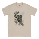 A Natural short-sleeve crewneck t-shirt featuring a watercolor-style graphic of a koala sitting on a tree branch with eucalyptus leaves. The brand name 'Myts' is printed in red inside the collar.