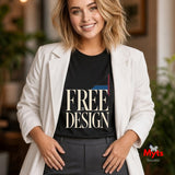 A woman wearing a black graphic T-shirt with the words 'FREE BY DESIGN' in cream lettering, layered under an open white blazer and dark gray trousers, standing in a softly blurred indoor setting.