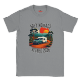 A gray short-sleeve crewneck t-shirt featuring a retro-style graphic of a green pickup truck towing a white camper on an orange dirt road, with a sunset and the text 'GREY NOMADS RETIRED 2026'. The brand 'MyTb' is visible on the inner neck label.