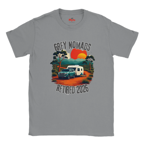 A gray short-sleeve crewneck t-shirt featuring a retro-style graphic of a green pickup truck towing a white camper on an orange dirt road, with a sunset and the text 'GREY NOMADS RETIRED 2026'. The brand 'MyTb' is visible on the inner neck label.
