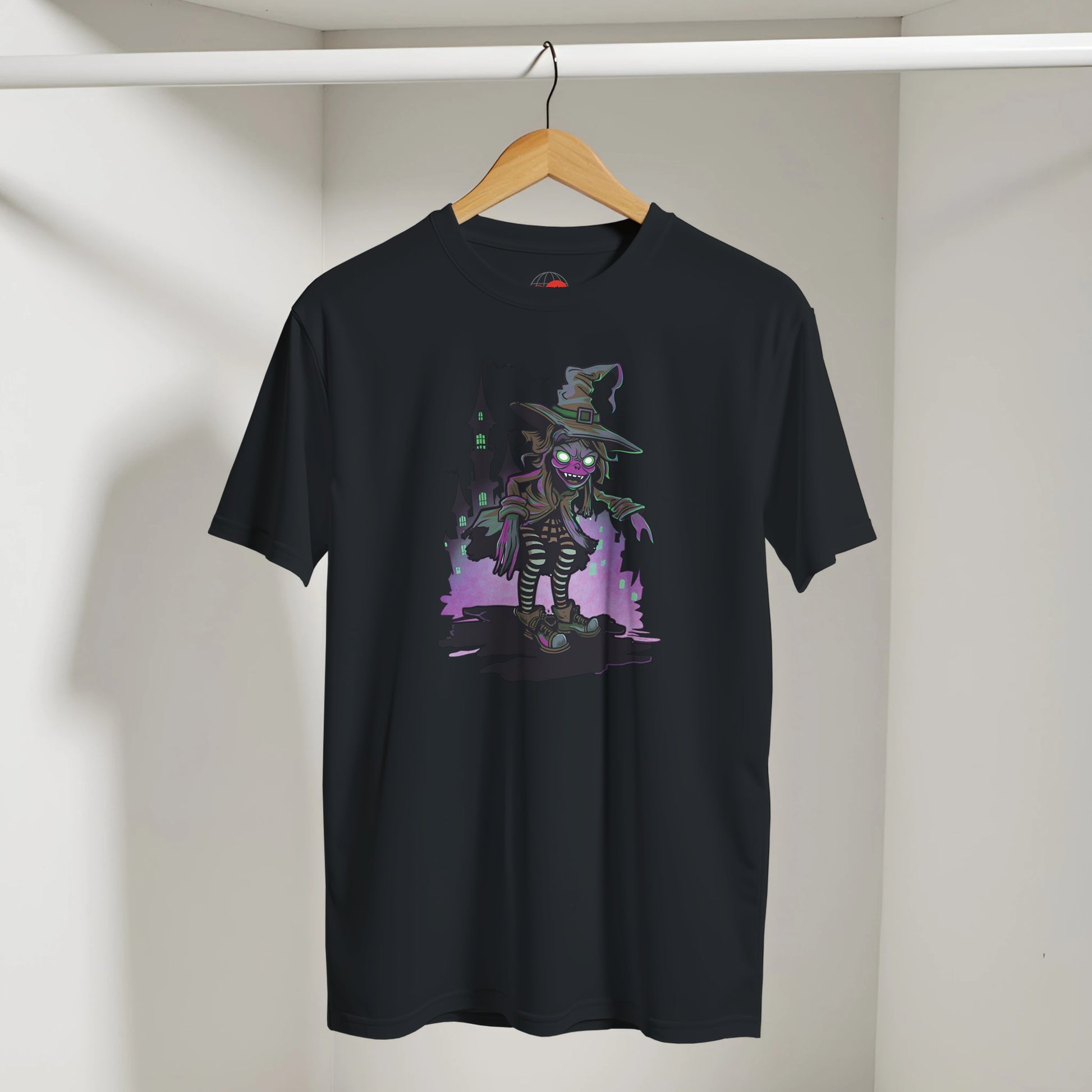 Black t-shirt with a colorful graphic of a character in a witch hat on a hanger against a plain background.