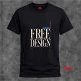 A black short-sleeve T-shirt with a graphic print reading 'FREE BY DESIGN' in beige, white, and red, displayed against a textured gray background.