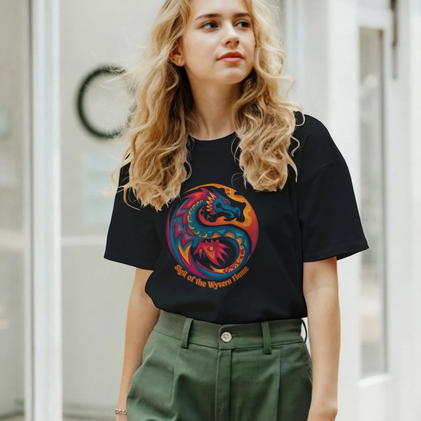 Front view of a woman wearing a black T‑shirt featuring a bold dragon symbol graphic centered on a soft cotton tee