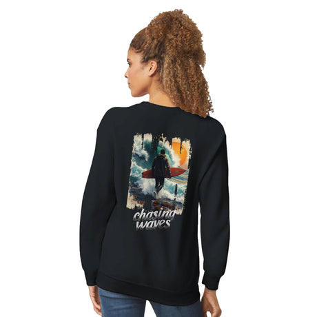 Person wearing a black sweatshirt with a graphic design on the back, featuring a surfer and the text 'Chasing Waves'.