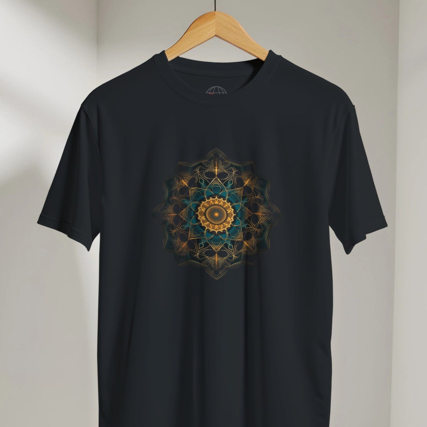 Black t-shirt with a colorful mandala design on a hanger against a neutral background