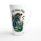 A white ceramic latte mug featuring a detailed illustration of an elderly fisherman holding a fishing rod, with a blue fish jumping in front of him. The text 'Old Man Fish' is printed above the illustration in a dark green font.