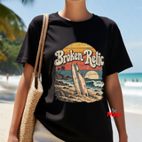 Woman wearing black Broken Relic vintage surf graphic T-shirt at the beach