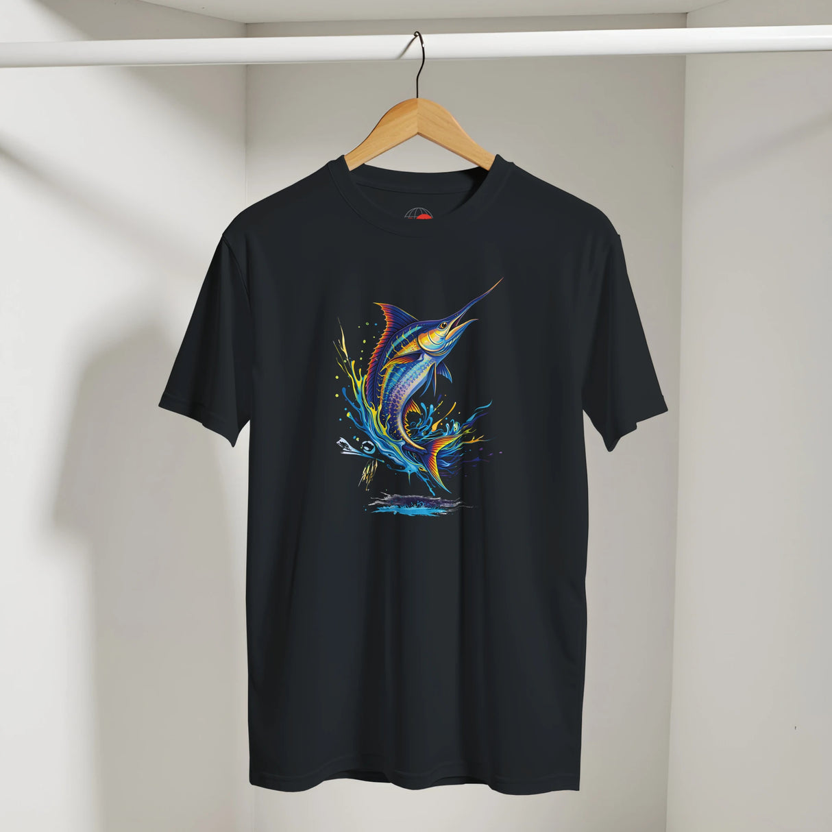 Black t-shirt with a colorful fish design on a hanger against a white wall.
