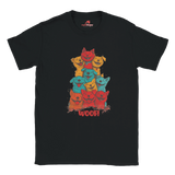 A flat lay black T-shirt featuring a vibrant graphic of cartoon puppies stacked in red, orange, blue, and yellow hues, with the playful text “WOOF!” below the design.