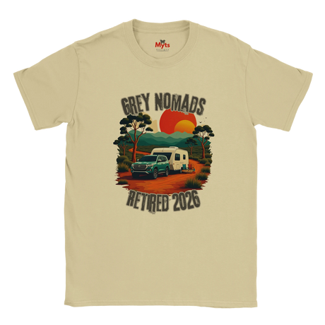 A Natural crewneck t-shirt featuring a retro-style graphic of a green camper trailer and truck on a dirt road with a sunset, accompanied by the text 'GREY NOMADS RETIRED 2026'. The brand 'Myths' is visible on the inner neck label.