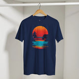 Navy blue t-shirt with a colorful sunset graphic on a wooden hanger against a white wall.