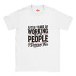 A white short-sleeve crewneck t-shirt with a graphic text print on the front that reads 'AFTER YEARS OF WORKING WITH PEOPLE I DESERVE THIS' in black and dark red lettering, displayed on a clean white background.