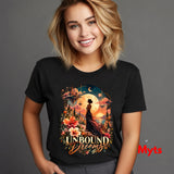 Smiling woman wearing a black Unbound Dreams T-shirt with colourful fantasy castles, moons and flowers.