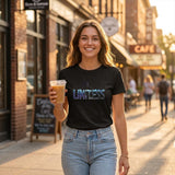 Woman holding a drink on a city street wearing a black t-shirt with 'Limitless' design.