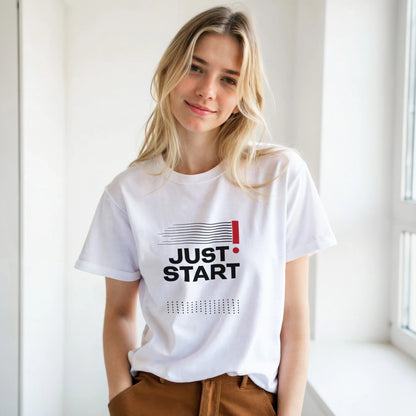 Woman wearing a white t-shirt with 'JUST START' text in a bright room.