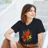 Woman wearing a black t-shirt with a colorful leaf design, sitting on steps.