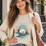 A woman wearing a Sand coloured oceanic design with the word UNBOUND at the bottom