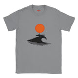 Sports Gray t-shirt with a graphic design of a person on a surfboard riding a wave under an orange sun, branded 'Myts'.
