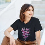 Woman wearing a black t-shirt with colorful heart design sitting outdoors.