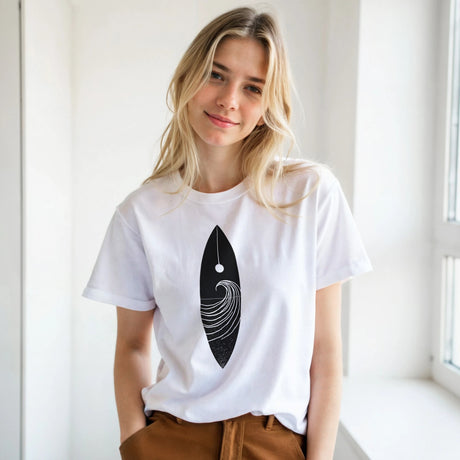 Woman wearing a white t-shirt with a black and white design, standing in a bright room.