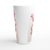 A tall white tapered cup featuring a delicate pink and red cherry blossom branch pattern printed on the sides, set against a clean white background.