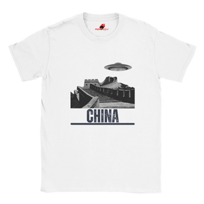 “White T-shirt with a vintage black-and-white Great Wall of China illustration and a UFO hovering above it, labeled ‘CHINA,’ designed by MytsDesigns.com”

