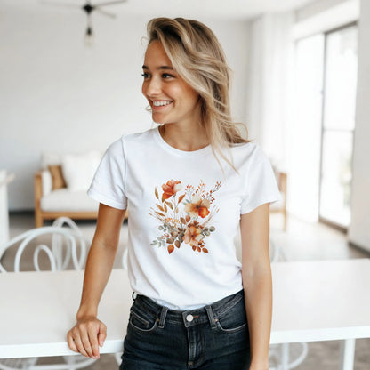 A woman wearing a white t-shirt with a floral design in a bright room.