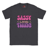 Front view of “Sassy Little Thing” T-shirt with groovy 70s-style typography on black cotton tee