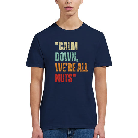 girl wearing A navy retro styled t-shirt, featuring distressed lettering "Calm Down, We're All Nuts" on a white background
