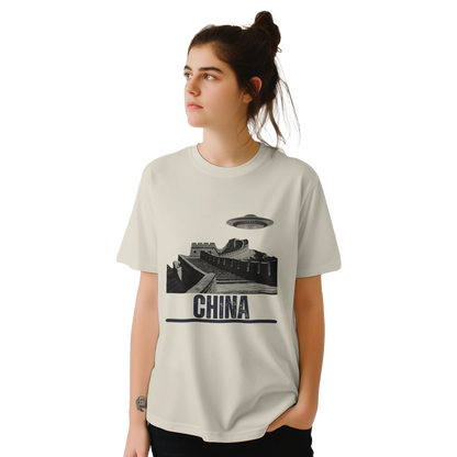 “Woman wearing a white T-shirt with a vintage black-and-white Great Wall of China illustration and a UFO hovering above it, labeled ‘CHINA,’ designed by MytsDesigns.com in a gym setting”


