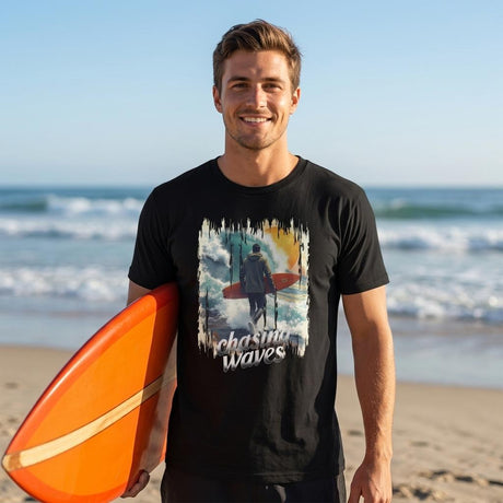 Man holding an orange surfboard on a beach with a 'Chasing Waves' t-shirt.