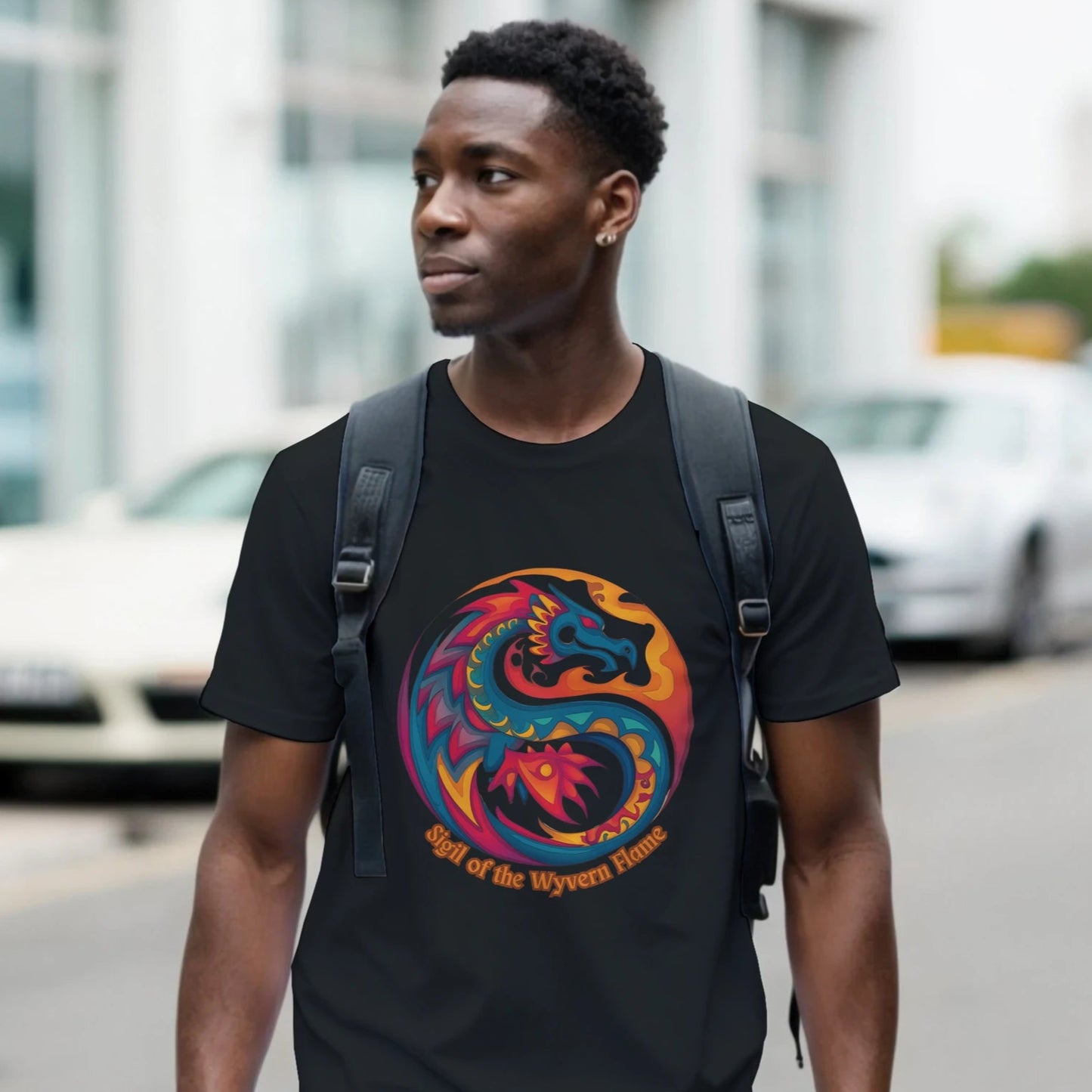 Front view of a man with a backpack walking the city streets wearing a black T‑shirt featuring a bold dragon symbol graphic centered on a soft cotton tee