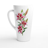 A tall white ceramic latte mug featuring a realistic botanical illustration of pink and white lilies with green leaves and buds on the front, set against a clean white background.