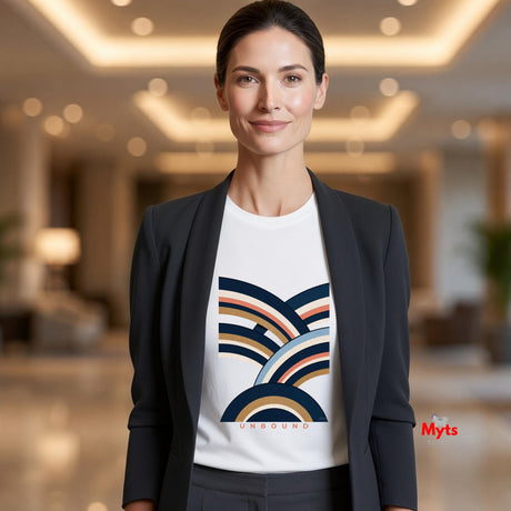A woman wearing a white crewneck t-shirt with a colorful retro wave graphic and a dark blazer, standing in a brightly lit, modern lobby.