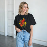 Woman wearing a black t-shirt with a jack-o'-lantern design, standing indoors.