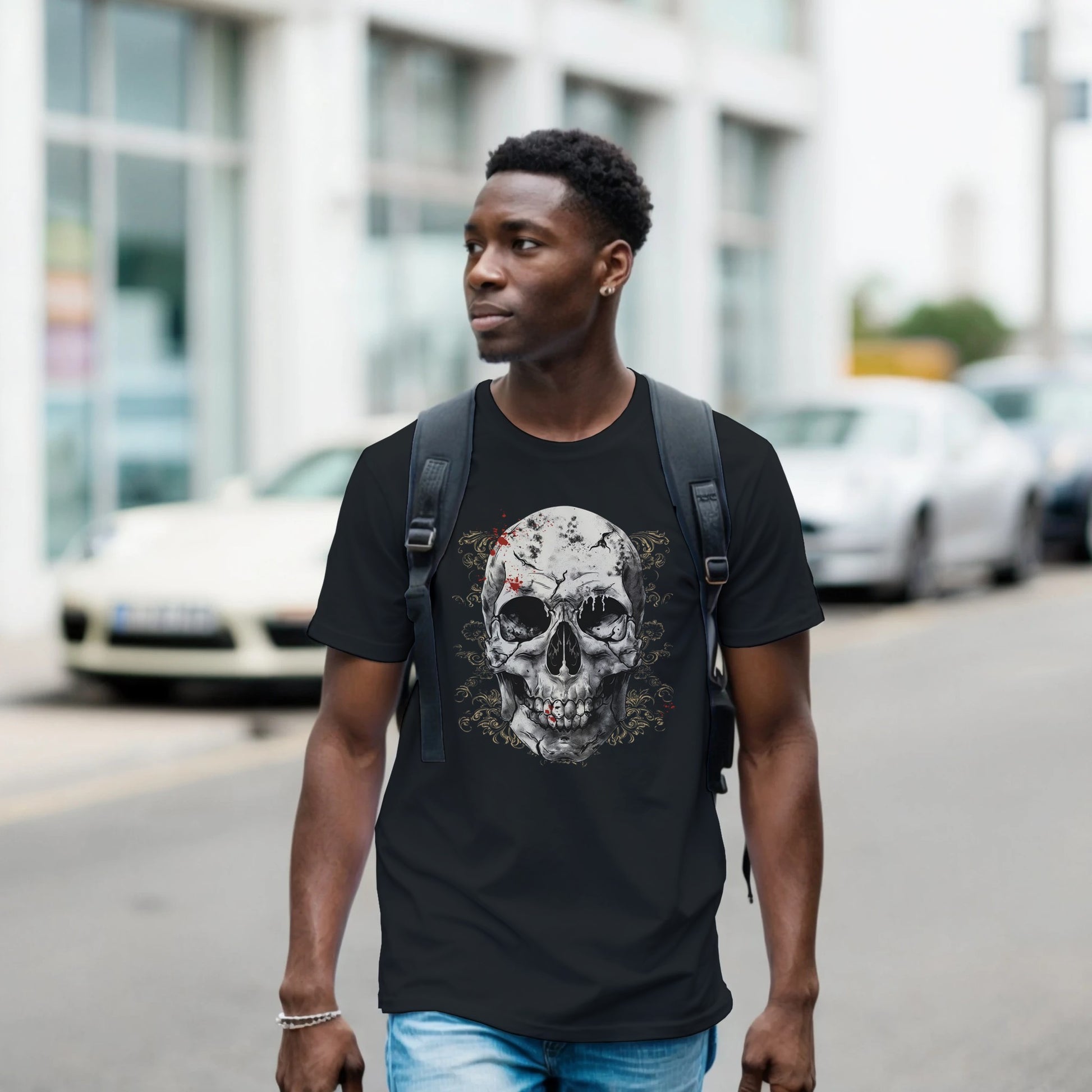 Man wearing a black t-shirt with a skull design on a street.