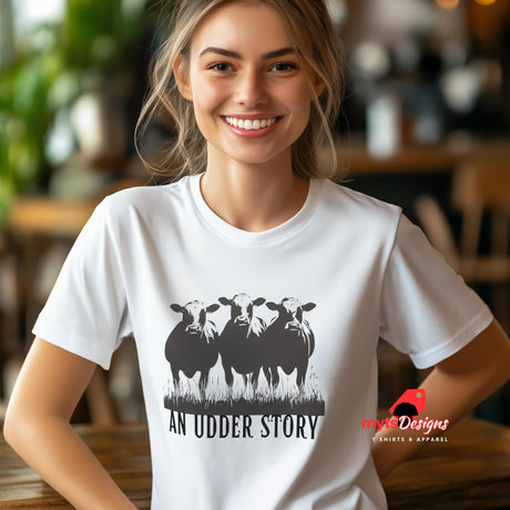 A young woman wearing a white cotton T-shirt featuring illustrated cows and text “An Udder Story” – humorous farm-themed graphic tee

