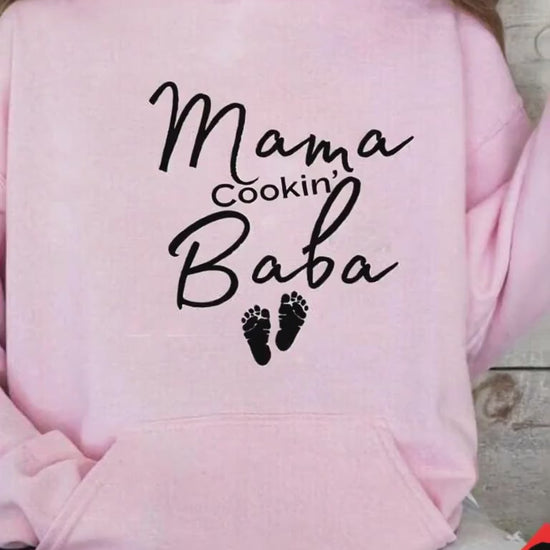 Girl in Pink Hoodie "Mama Cookin' Baba" sittin on a couch
